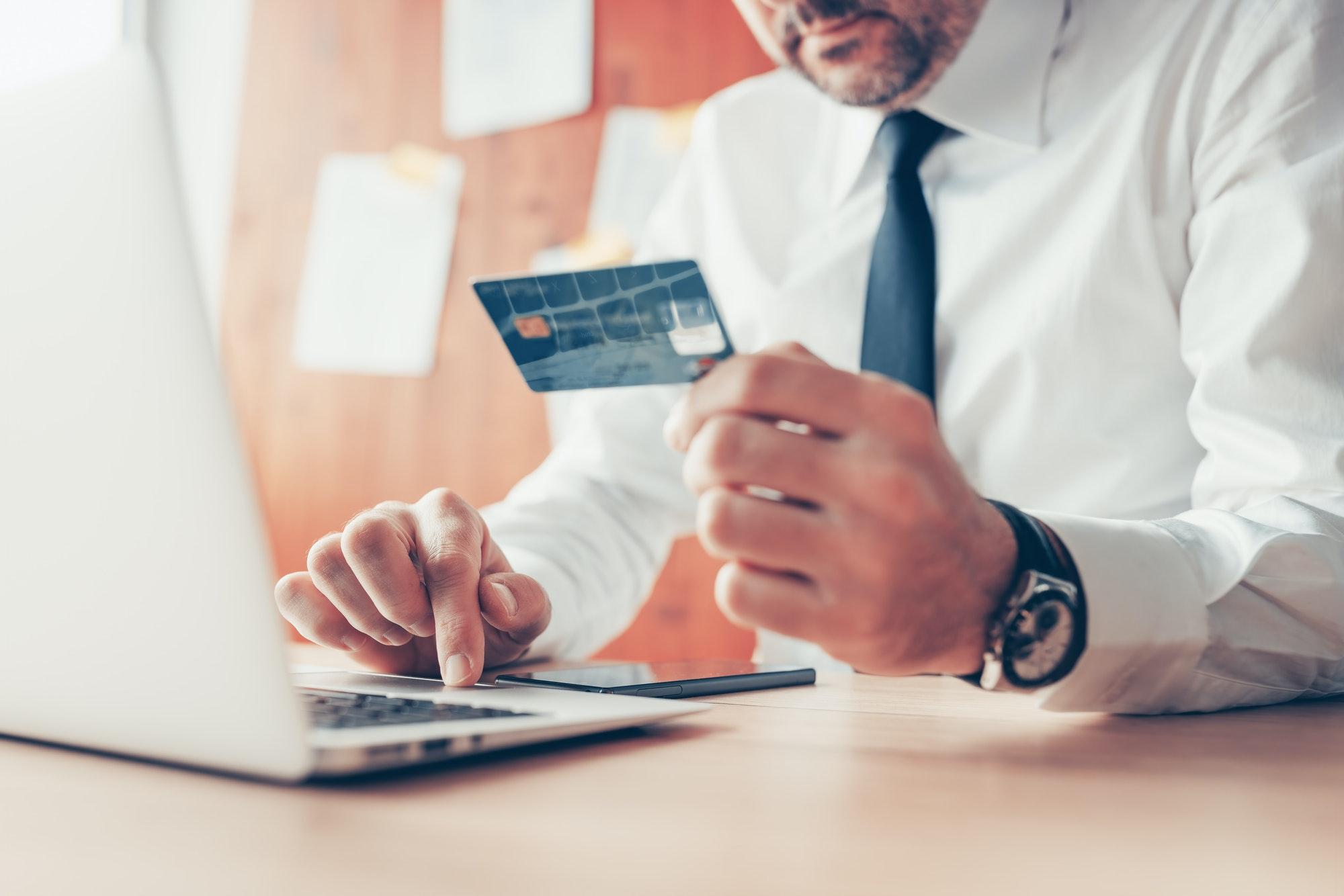 E-business, businessman using credit card and laptop computer for online financial transaction