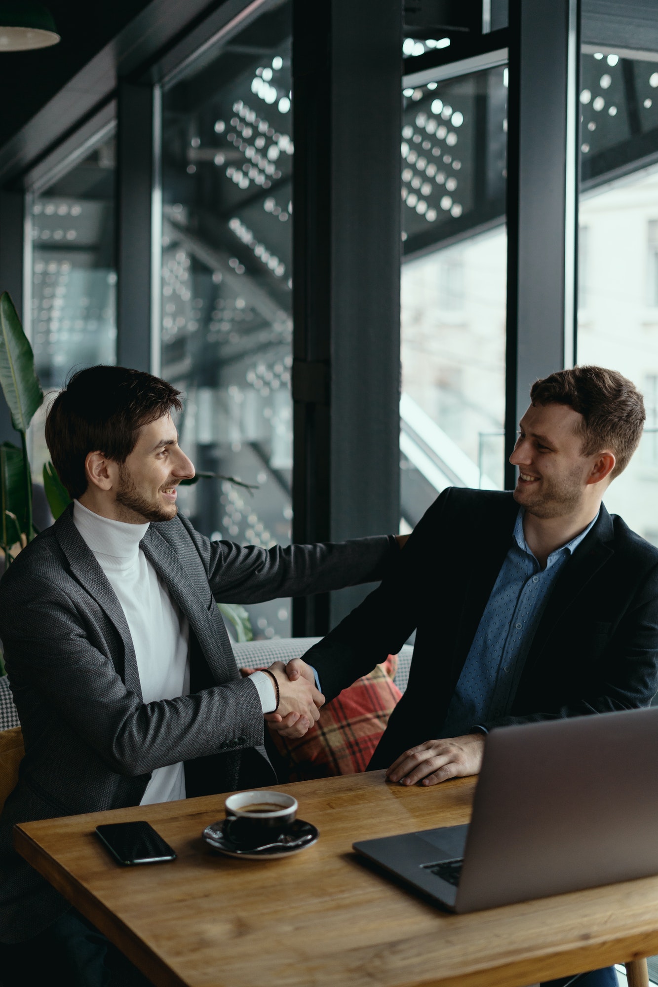 Two businessmen shaking hands while meeting in lobby